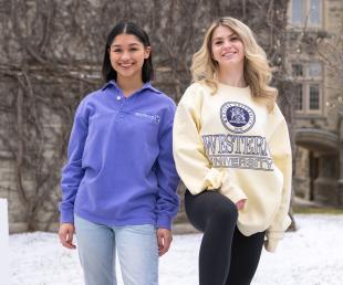 Two students posing with new merch from Western Bookstore